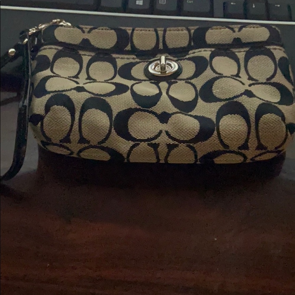 Classic Coach wristlet with turn lock closure.